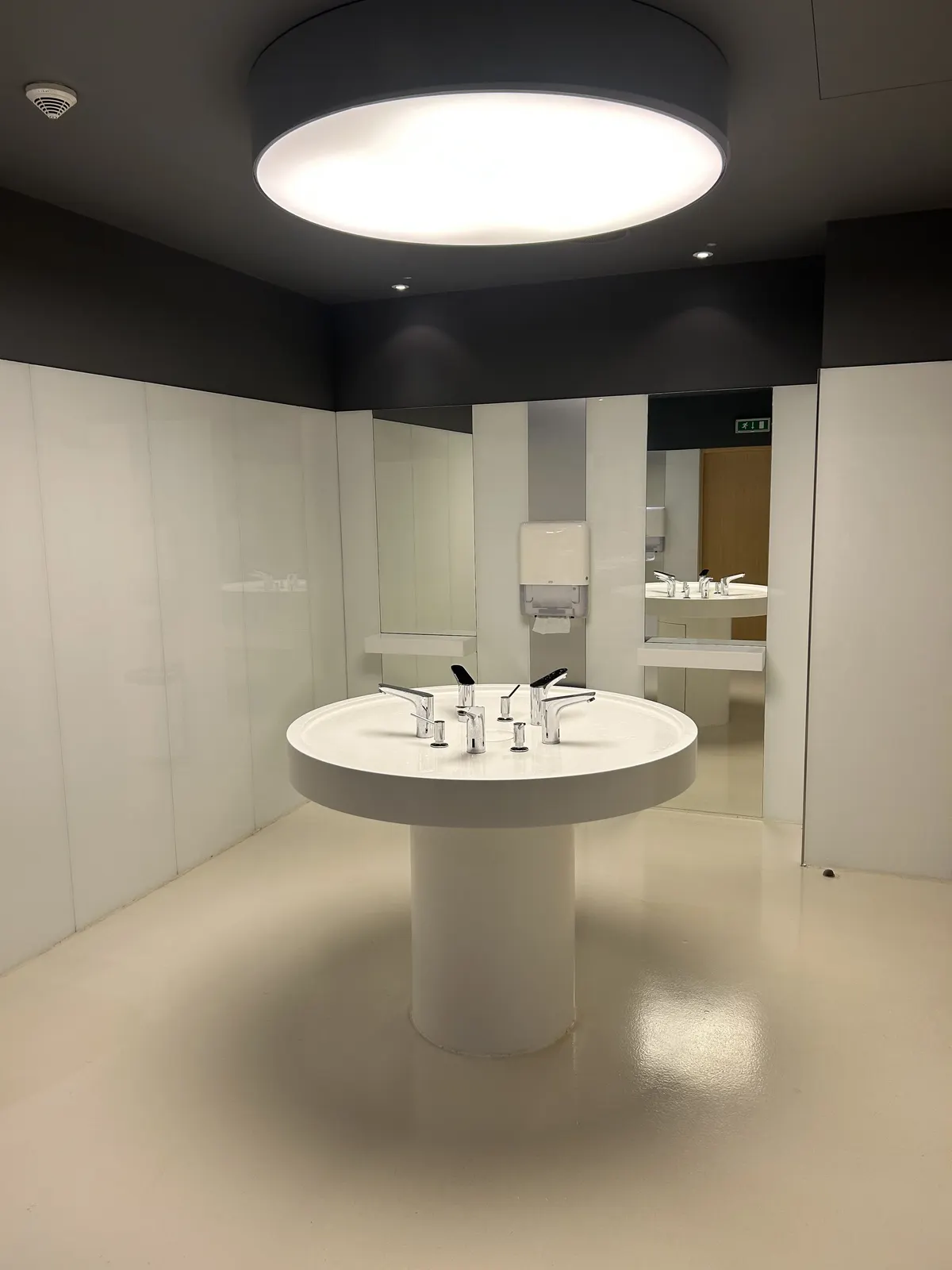 Bright modern washroom with a round vanity and chrome faucets