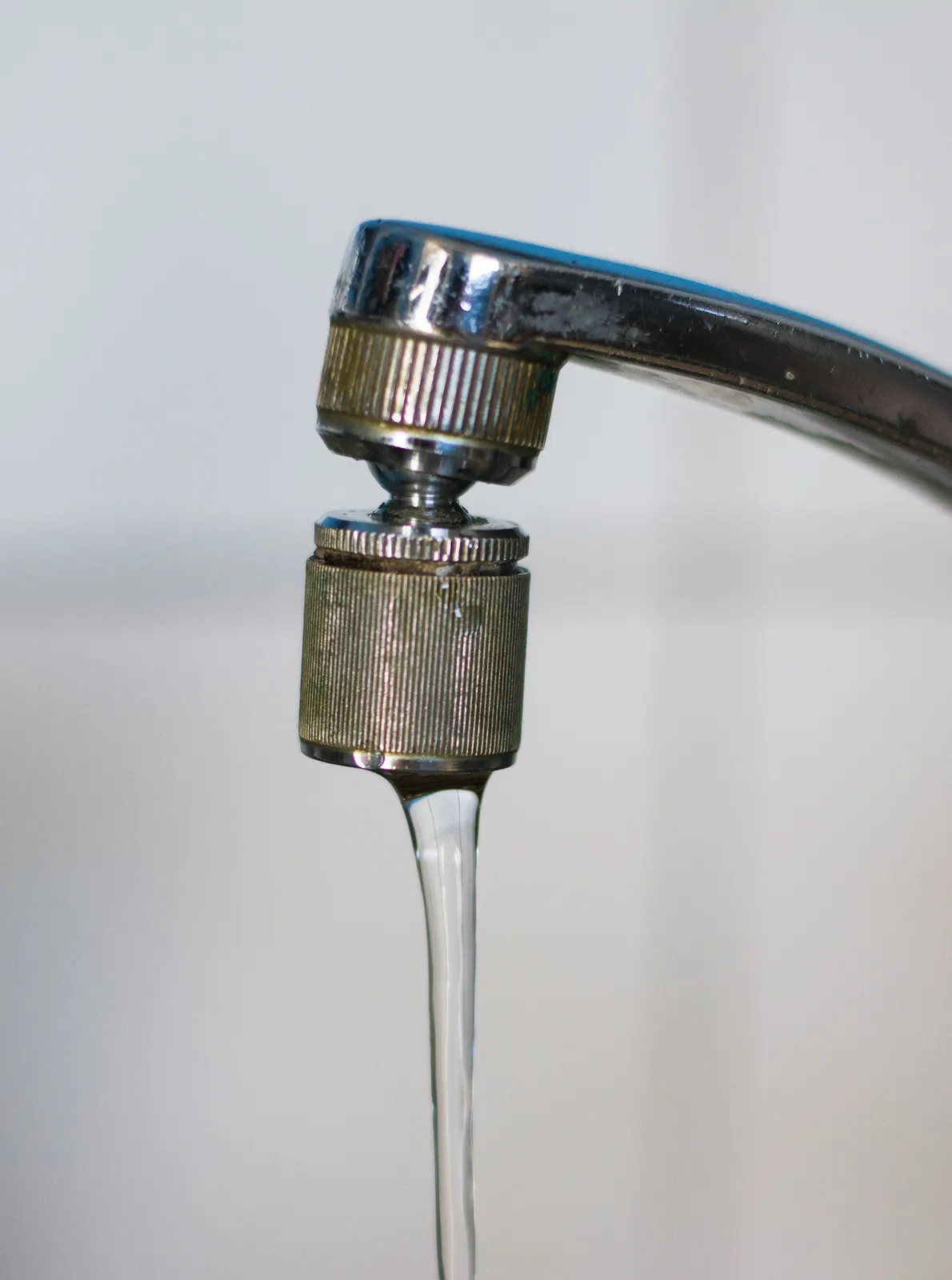 Chrome faucet running a thin stream of water