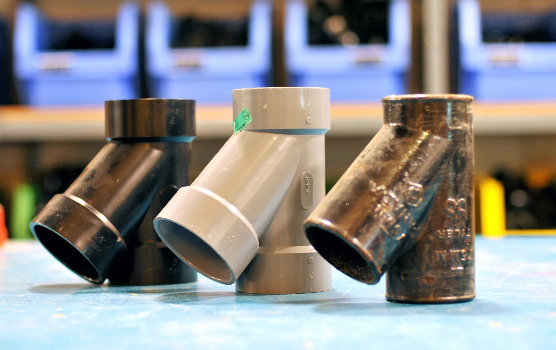 Copper and plastic drain fittings lined up on a workbench